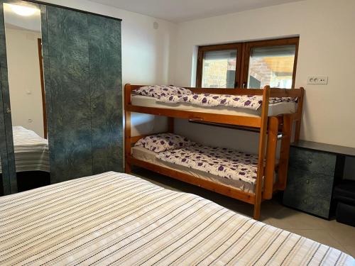 Lipik的住宿－Kuća za odmor Balog，一间卧室配有两张双层床和镜子