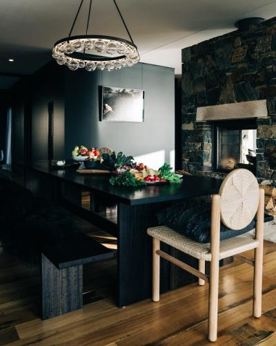 a dining room with a black table and a chair at Siren Tasmania in White Beach