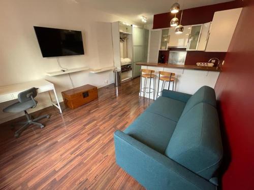 巴黎的住宿－Studio Jean Mermoz CityCosy，一间带蓝色沙发的客厅和一间厨房