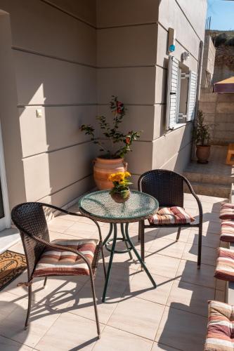a patio with a glass table and two chairs at Niki's House in Gournes