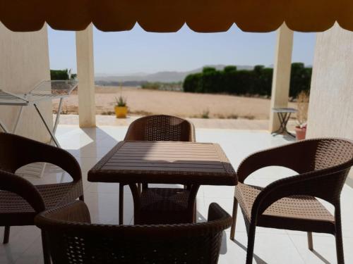 een houten tafel en stoelen op een patio bij Luxury Sea-view 2 bedrooms apartment in Hadaba in Sharm El Sheikh