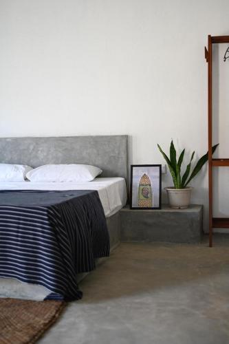 アハンガマにあるVIVO Brand New Beach Studio Hot Water Fast Internetのベッドルーム(ベッド1台、鉢植えの植物付)
