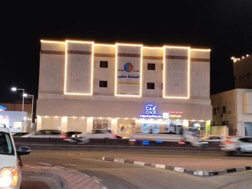 a building with lights on the side of it at night at الساعه 60 الفندقيه in Dammam
