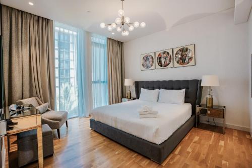 a hotel room with a bed and a chair at Nasma Luxury Stays - Gorgeous Waterfront Apt With Incredible Sea Views in Dubai