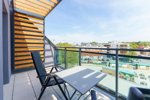 a balcony with a table and chairs and a view of a pool at Bel Mare Międzyzdroje Apartment with Balcony by Renters in Międzyzdroje