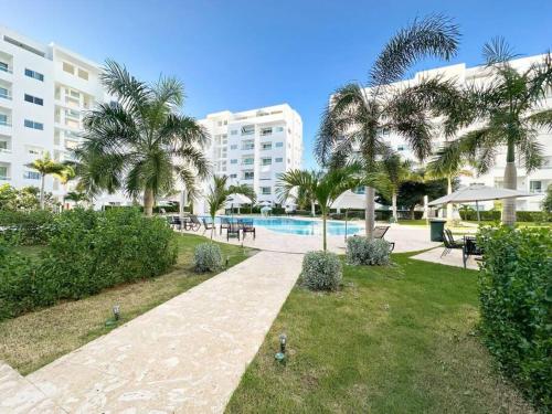 a resort with a swimming pool and palm trees at Juan Dolio Apartamento 204D 2Br Pool View in Juan Pedro