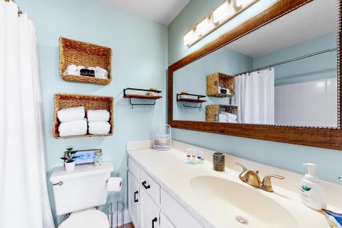 een badkamer met een wastafel en een spiegel bij Top floor Condo with gorgeous Bay view Overlooking the Pool in Orange Beach