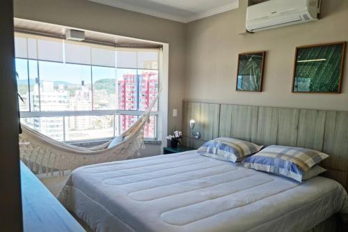 um quarto com uma cama grande e uma janela grande em Campinas Penthouse - Cobertura Luxo com Piscina Privativa em São José