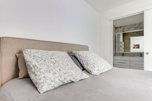 um quarto com uma cama com duas almofadas em Chic appartement en plein coeur de Levallois-Perret em Levallois-Perret