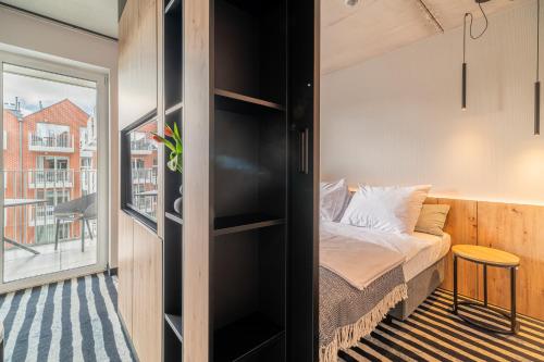 a small bedroom with a bed and a window at Nadmorski Loft GREEN PORT SPA in Kołobrzeg