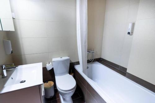 a bathroom with a toilet and a tub and a sink at Kaimaktsalan maisonette in Palaios Agios Athanasios