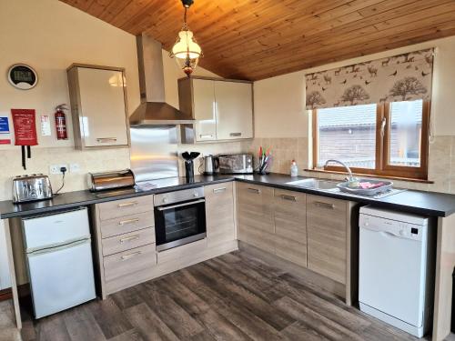 a kitchen with stainless steel appliances and wood floors at Lomond 6 with Private Hot Tub - Fife - Loch Leven - Lomond Hills in Kelty
