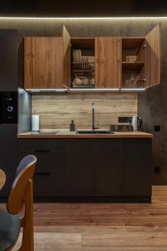 a kitchen with wooden cabinets and a sink at Phoenix Medical Resort in Skhidnitsa