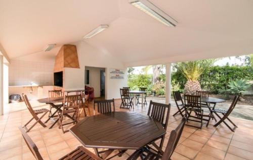 eine Terrasse mit Tischen und Stühlen und eine Küche in der Unterkunft Flamingos Apartment with 2 swimming pool com check in e check out ao domingo em julho e agosto in Albufeira