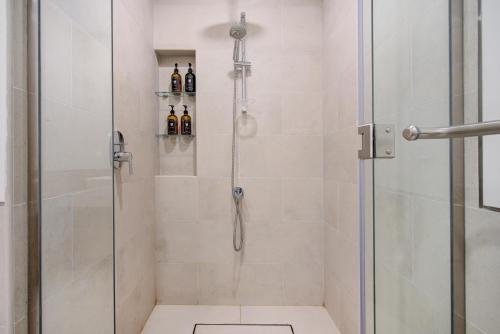 a bathroom with a shower with a glass door at Trophy - Burj Al Arad Maison de Reve in Dubai