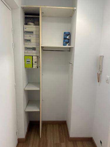 d'un placard avec des murs blancs et des étagères blanches. dans l'établissement Appartement cosy, proche Paris, à Rosny-sous-Bois