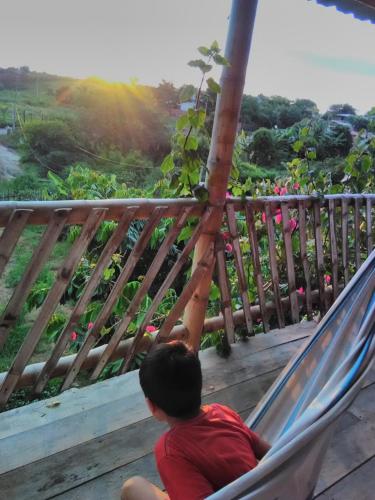 un jeune garçon assis dans un hamac sur une terrasse couverte dans l'établissement Casa completa en Puerto Cayo, à Puerto Cayo