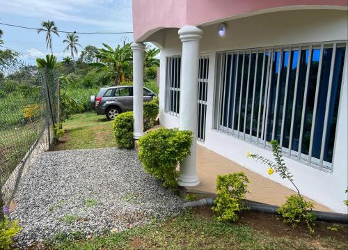克里比的住宿－Akiba Guests Houses，一个带门廊和停车位的房子