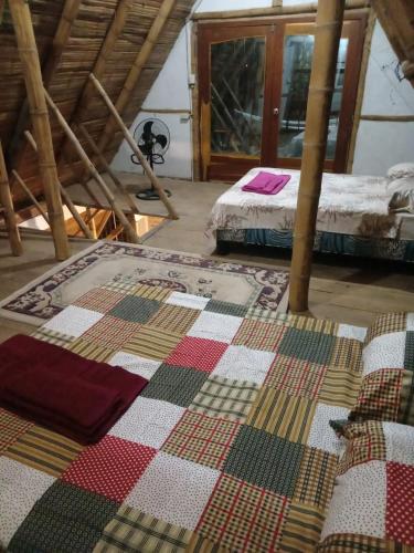 a room with two beds and a quilt on the floor at Casa completa en Puerto Cayo in Puerto Cayo