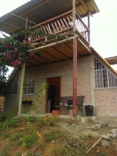 une maison avec un auvent et un banc devant elle dans l'établissement Casa completa en Puerto Cayo, à Puerto Cayo