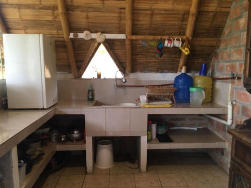 La cuisine est équipée d'un évier et d'un réfrigérateur. dans l'établissement Casa completa en Puerto Cayo, à Puerto Cayo