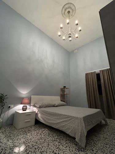 a bedroom with a bed and a chandelier at Spacious room, king size bed, balcony, mirrors and luxury lights. in Mosta