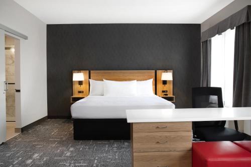 a hotel room with a bed and a desk at Ramada by Wyndham Cochrane in Cochrane