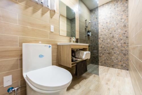 ein Bad mit einem WC und einer Dusche in der Unterkunft 暖日民宿 in Xingjian