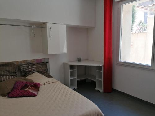 une chambre avec un lit, une table et une fenêtre dans l'établissement ENTRE PLAGES ET CALANQUES, à La Ciotat