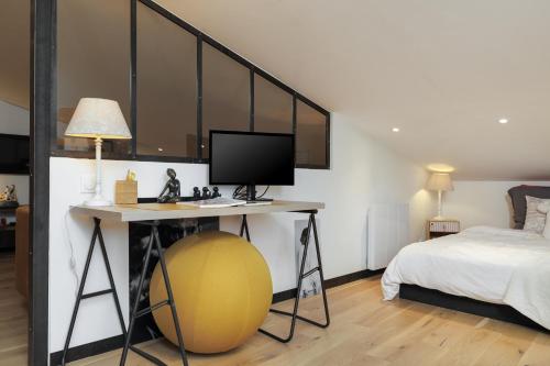 a bedroom with a desk with a computer on a ball at Perle rare au coeur de Bordeaux in Bordeaux
