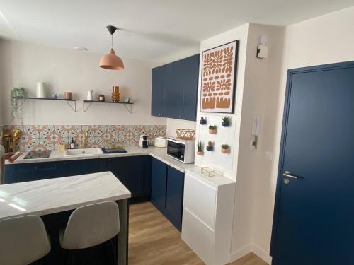 une cuisine avec des armoires bleues et un comptoir dans l'établissement Appartement entier centre historique DINAN, à Dinan
