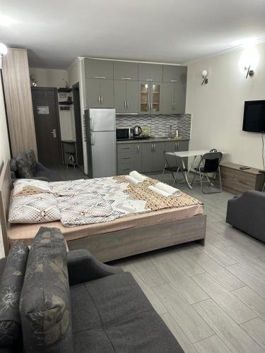 a living room with a large bed and a kitchen at ORBI City studio 536 in Batumi