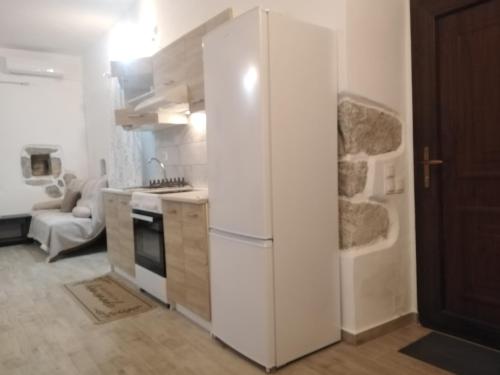 a kitchen with a white refrigerator and a stove at Pandera areopoli in Areopolis