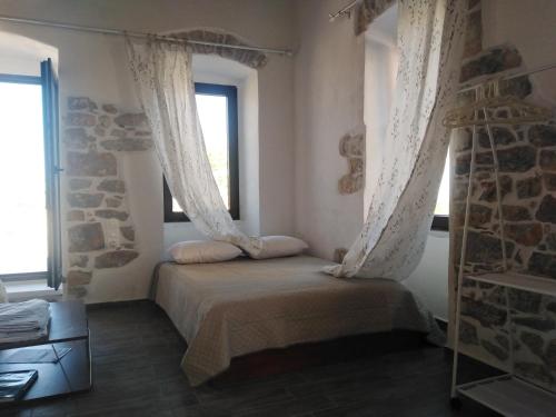 a bedroom with a bed with curtains and a window at Pandera areopoli in Areopolis