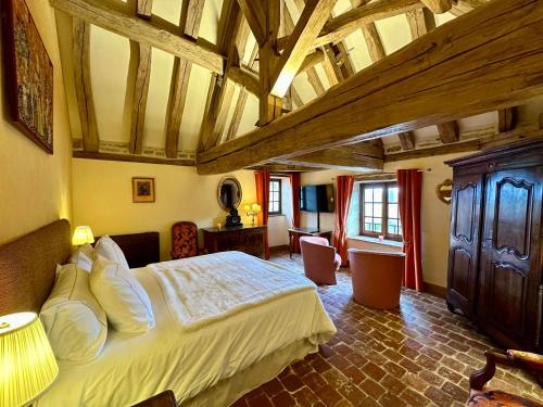 ein Schlafzimmer mit einem großen Bett in einem Zimmer in der Unterkunft L'Échoppe est belle et la Seigneurie in Châteauneuf