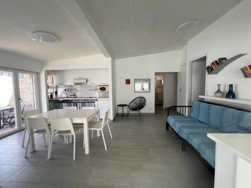 Casa Azzurra في Germignaga: غرفة معيشة مع أريكة وطاولة وكراسي