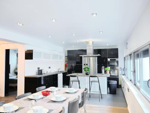 a kitchen and dining room with a table and chairs at Spacieux appartement aux portes de Paris, parking gratuit in Bagnolet