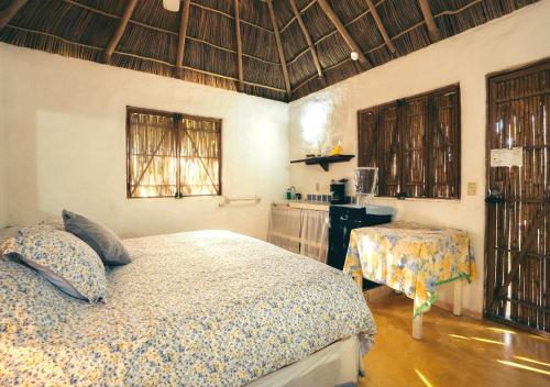 a bedroom with a bed and a table in it at Junto al Rio Bungalows & Suites in Sayulita