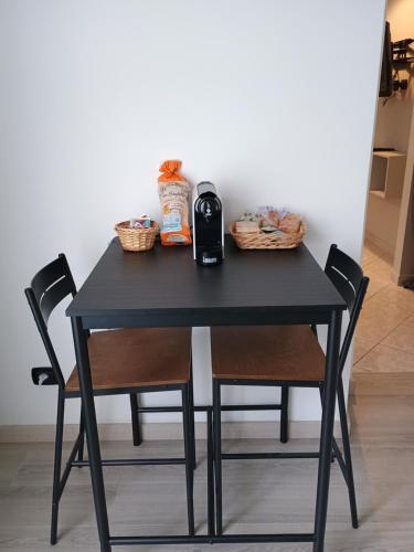 a black table with two chairs and a bottle of wine at Casa Di Francesco in Velletri
