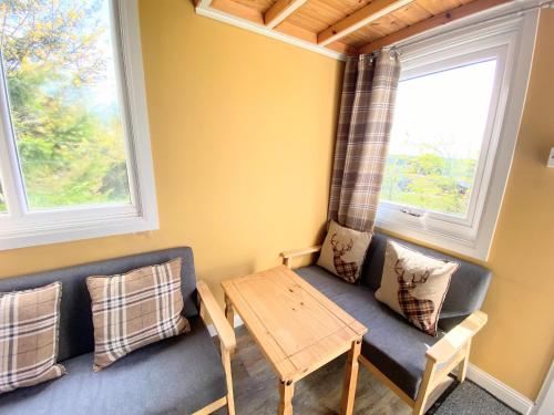 een woonkamer met een bank en een tafel bij Blair Tiny House with Private Hot Tub - Pet Friendly- Fife - Loch Leven - Lomond Hills in Dunfermline