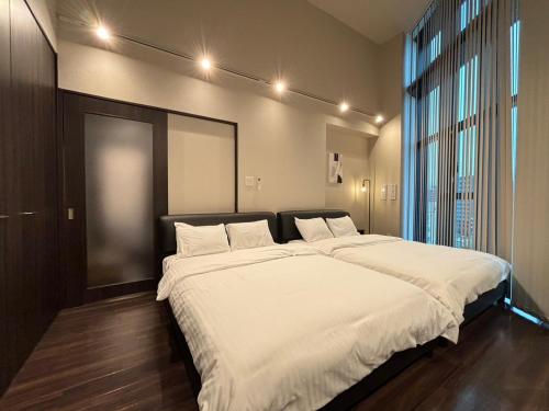 a bedroom with a large bed with white sheets at Neighbor's Penthouse 竹屋 in Hiroshima