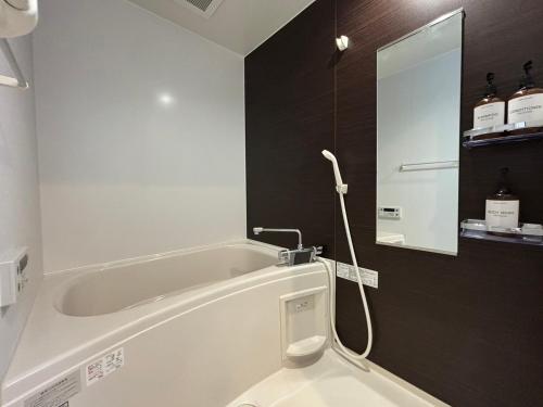 a bathroom with a bath tub and a mirror at Neighbor's Penthouse 竹屋 in Hiroshima
