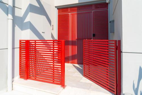 two red metal gates on the side of a building at The HostMaster Urban Bliss in Athens