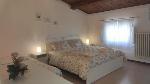 um quarto branco com uma cama e uma janela em Da Panco e Vera em Porto Recanati