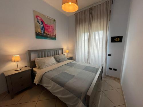 ein Schlafzimmer mit einem Bett und einer Lampe auf einem Tisch in der Unterkunft SEA4USALERNO seafront in Salerno