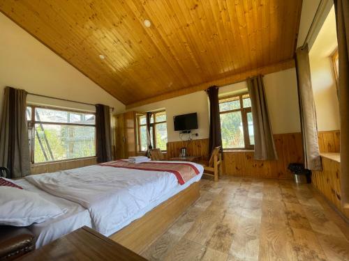 ein Schlafzimmer mit einem großen Bett und einer Holzdecke in der Unterkunft Heavens retreat,Club nirvana stays in Vashisht