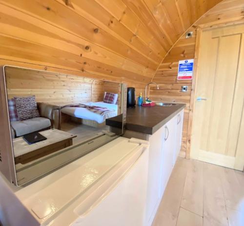 uma pequena casa com uma cozinha e uma cama em Pond View Pod 1 with Outdoor Hot Tub - Pet Friendly - Fife - Loch Leven - Lomond Hills em Kelty
