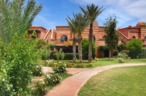 ein Haus mit Palmen und einem Gehweg in der Unterkunft La Perle de l'Atlas by Golf Resort in Marrakesch