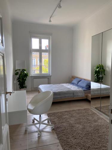 een slaapkamer met een bed en een stoel erin bij Słoneczny Apartament w Centrum in Słupsk