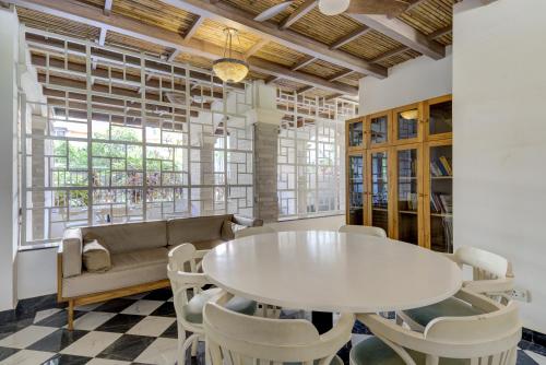 a dining room with a white table and chairs at Greenspace 2BHK with resort style amenities in Vasco Da Gama